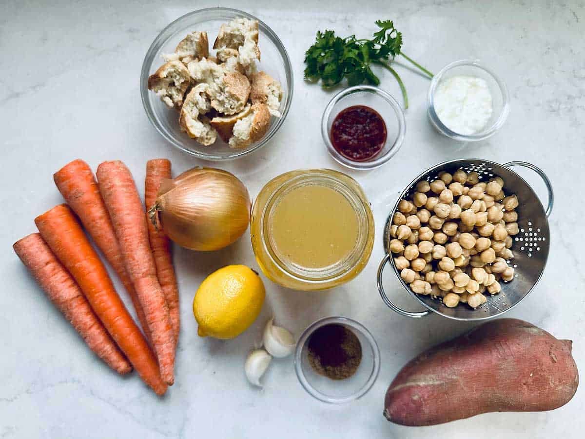 A table with food ingredients, including fresh vegetables and spices ready to prepare a flavorful Moroccan Soup.